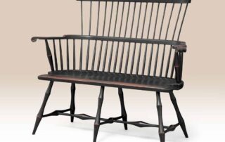 Historical Lancaster Windsor Settee with carved knuckles and bamboo style turnings in antique black over red crackle finish.