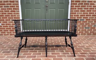 Historical Low Back Windsor Settee with antique black over red crackle finish, ideal for hallways, foyers, or living rooms, American made.