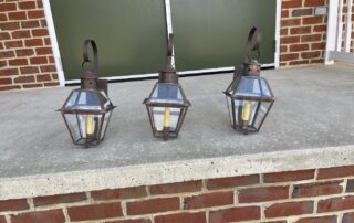 Set of three Charlottesville Wall Lights with a dark brass finish, ideal for country, early American, colonial, or contemporary settings.