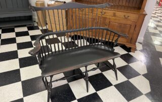 Historical Fan Back Windsor Settee with carved knuckles in antique black over red crackle finish, ideal for hallway or living room, American made.