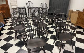 Set of 8 Windsor Chairs with 2 Sack Back Armchairs and 6 Bow Back Side Chairs in Antique Black over Red Painted Finish.