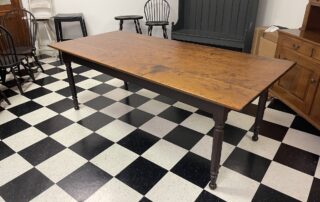 7ft X 38 1/4in Lancaster County Plank Top Farm Table with distressed cherry wood top and antique black over red base, handcrafted in Pennsylvania.