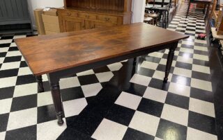 7ft Gettysburg Farmhouse Table with distressed cherry wood top and antique black over red base, handcrafted in Pennsylvania.