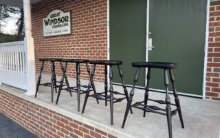 Farmhouse Bar Stools in Windsor style with antique black over red crackle finish and shaped seat, American-made.