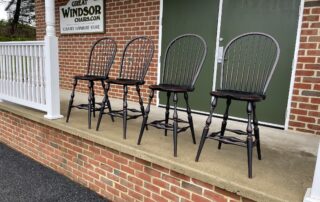 Set of 4 Historical Bow Back Windsor Stools with 25in seat height, antique black over red crackle finish, non-swivel, American made.