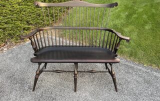 Historical Fan Back Windsor Settee with carved knuckles and carved ears in Antique Black over Red Crackle, American-made farmhouse bench