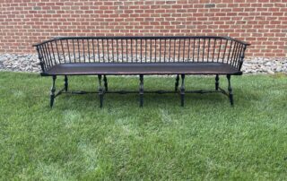 Historical Long Low-Back Windsor Settee with Antique Black over Red Crackle Finish and classic Windsor style vase legs