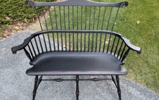 Fan Back Windsor Settee with bamboo-style turned legs, carved knuckles, and Antique Black over Red Crackle Finish.