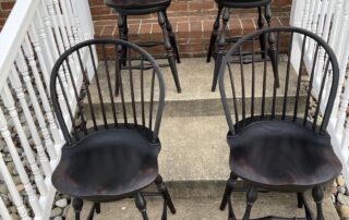 Set of Four Swivel Low Bow Back Windsor Counter Stools with turned legs and antique black over red crackle finish, crafted in the USA.