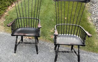 Pair of Philadelphia Comb Back Windsor Armchairs with carved knuckles and antique black over red crackle finish, handcrafted in the USA.