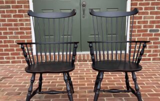 Pair of New England Fan Back Windsor Armchairs with turned legs and antique black over red finish, crafted in Pennsylvania.