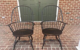 Pair of Sack Back Windsor Armchairs with turned legs, shaped seats, and antique black over red crackle finish, handcrafted in the USA.