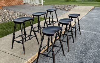 A set of 6 Saddle Seat Bar Stools, crafted in the USA with a Windsor-style design.