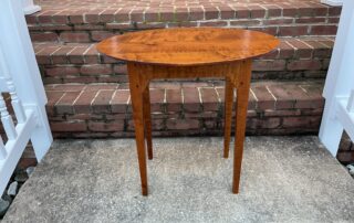A handcrafted Oval Top Shaker Side Table made from Tiger Maple Wood, showcasing natural beauty and durability.