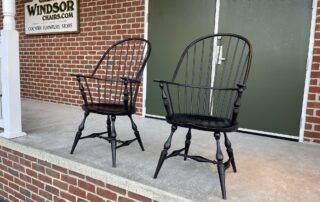 2 Historical Sack Back Windsor Armchairs with antique black over red crackle finish, mortised and wedged construction, and classic design.