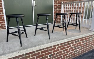 Four Historical PA Counter Stools with turned legs, Windsor style, and antique black over red crackle finish. Ideal for kitchen counters.