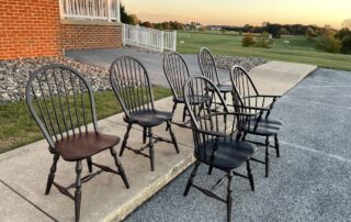 Six Jefferson Windsor Chairs with classic Windsor style, turned legs, and antique black over red finish. Includes armchairs and side chairs.