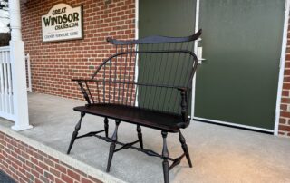 American-made Windsor settee with shaped seat and mortised and wedged legs.