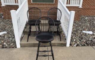 Set of 3 Swivel Counter Stools with low bow backs and antique black over red crackle finish. Made in the USA.