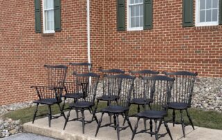 Set of 8 Historical Windsor Chairs with antique black over red crackle finish, including 2 armchairs and 6 side chairs. Made in the USA.