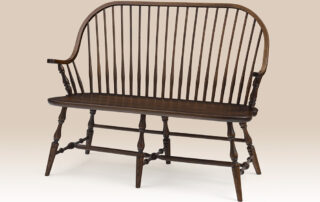 Oak Continuous Arm Windsor Settee with a Windsor-style design, turned legs, and a Pennsylvania Walnut finish. Made in Pennsylvania.