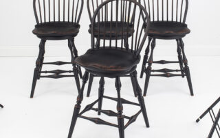 Set of 4 Historical Swivel Low Bow Back Windsor Stools with antique black over red finish.