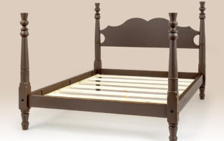 Historical Newtown Thistle Bed with shaped headboard and thistle motif in historical brown over natural finish.