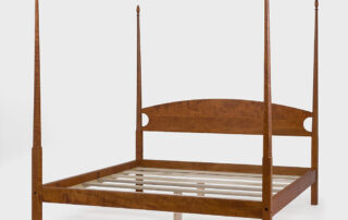 Pencil post bed with tapered posts and simple headboard, designed for farmhouse, traditional, or modern bedroom interiors.